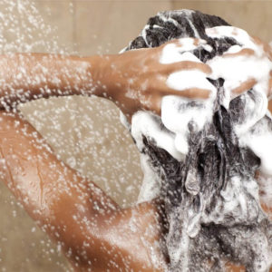 fille en train de se laver les cheveux sous la douche
